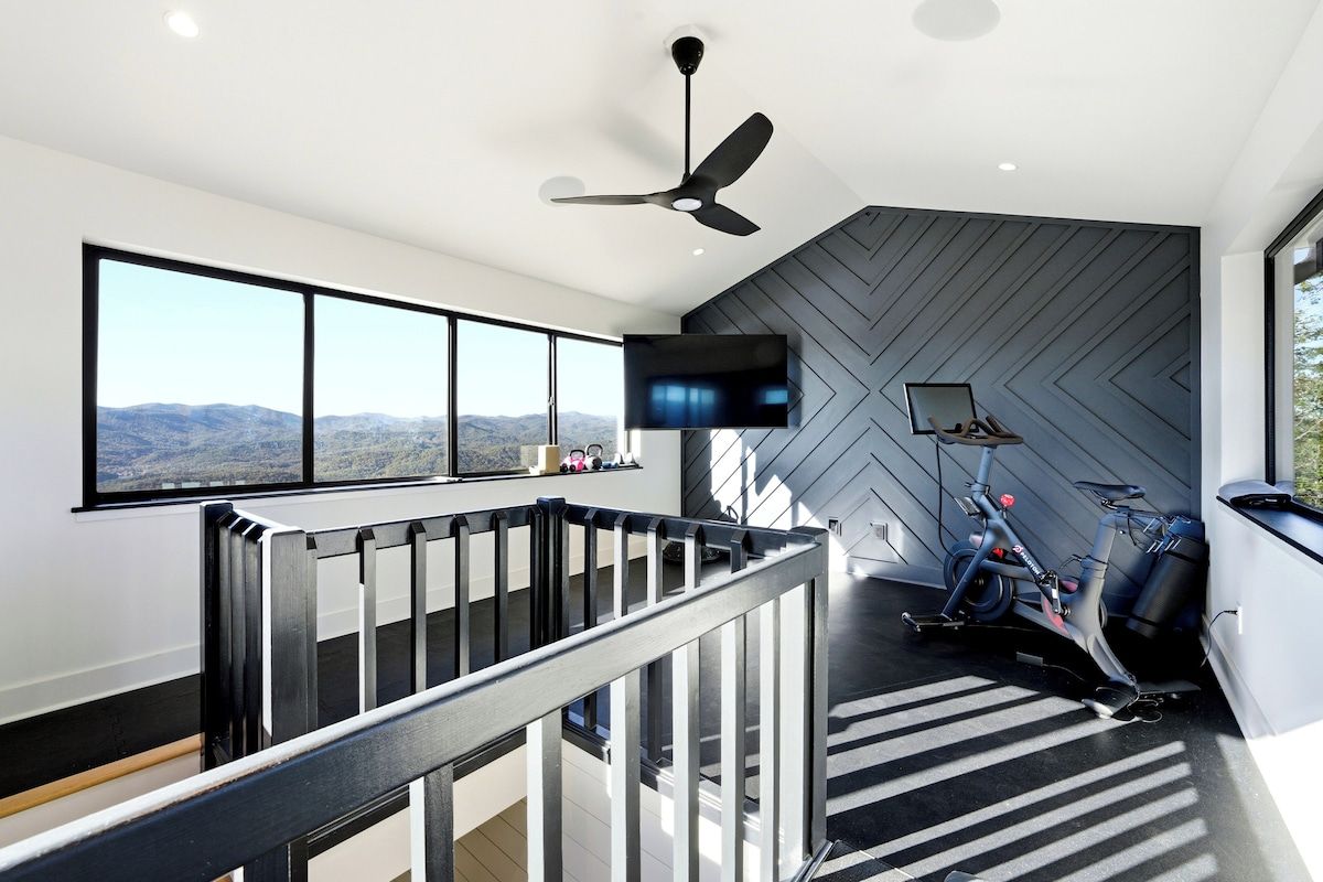 Private rooftop gym with spin bike, pull-up station & panoramic Blue Ridge Mountain views — stay active with a view at this luxury Lake Burton retreat in Tiger, Georgia.