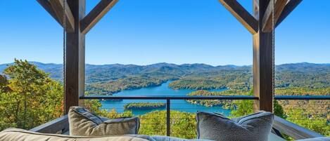 A wooden deck with a view of a lake and mountains.