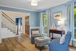 A room with a wooden staircase, a blue wall, a window with curtains, a lamp, and a chessboard on a table. - Lakeside Luxury: Private Dock, Kayaks, Game Room (Soddy-Daisy)