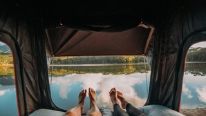 Une tente offrant une vue sur un lac paisible et une forêt.