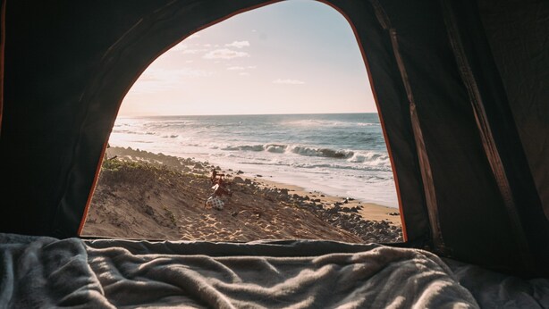 Une tente avec vue sur une plage et l’océan.
