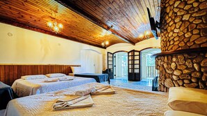 Habitación de hotel con techos de madera, paredes de piedra y una cama grande con toallas.
