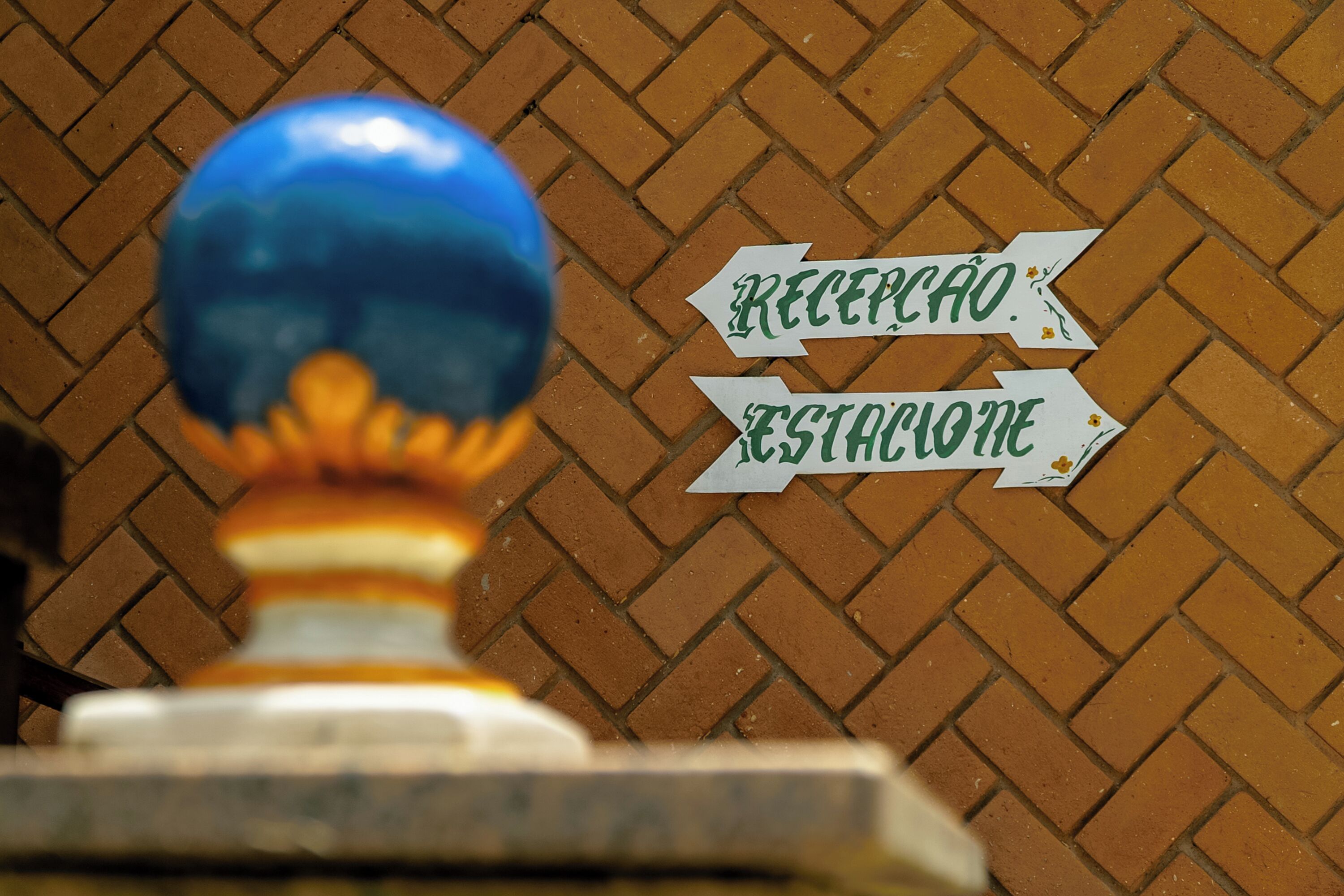 A reception sign with directional arrows on a brick wall.