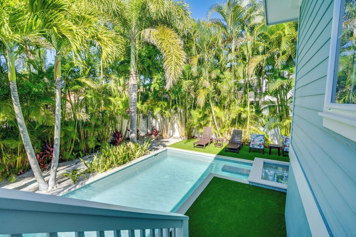 A swimming pool with a view of a lush garden and a building.