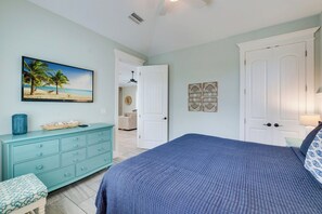 Un dormitorio con cama, cómoda, un cuadro y una puerta.