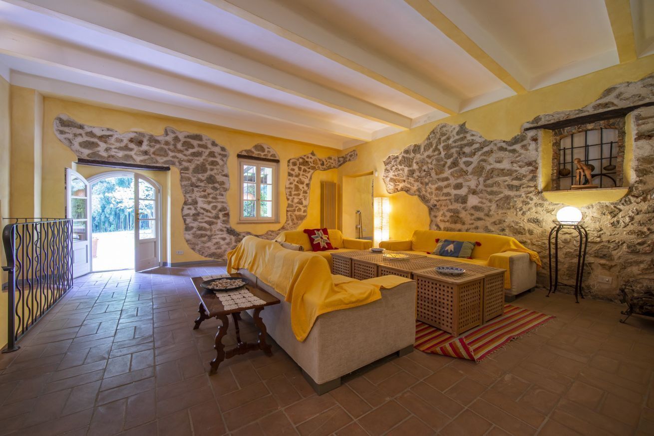 Une pièce aux murs de pierre, avec un canapé, une table et une lampe.