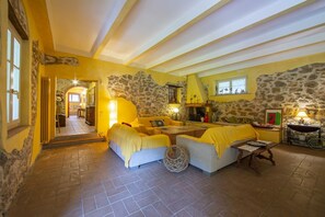 Una camera accogliente con una parete in pietra, un divano, un tavolo e un letto.