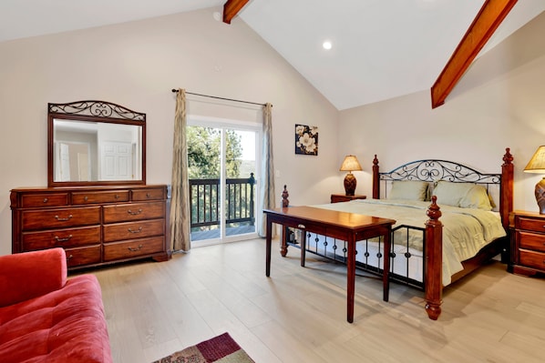 A bedroom with a bed, dresser, and a large mirror.