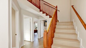 Una escalera con balaustres de madera y piso de color claro.