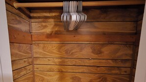 A wooden-paneled room with a sloped ceiling and a built-in shelf.
