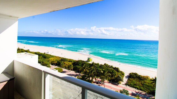 Ein Balkon mit Blick auf Strand und Meer.