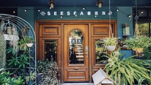 A wooden door with a sign above it, surrounded by various potted plants. - sees the sea and sea view boutique B&B (Shenzhen)