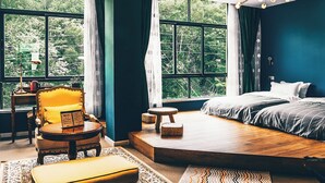 A bedroom with a large window, a bed, a chair, a small table, and a rug. - sees the sea and sea view boutique B&B (Shenzhen)
