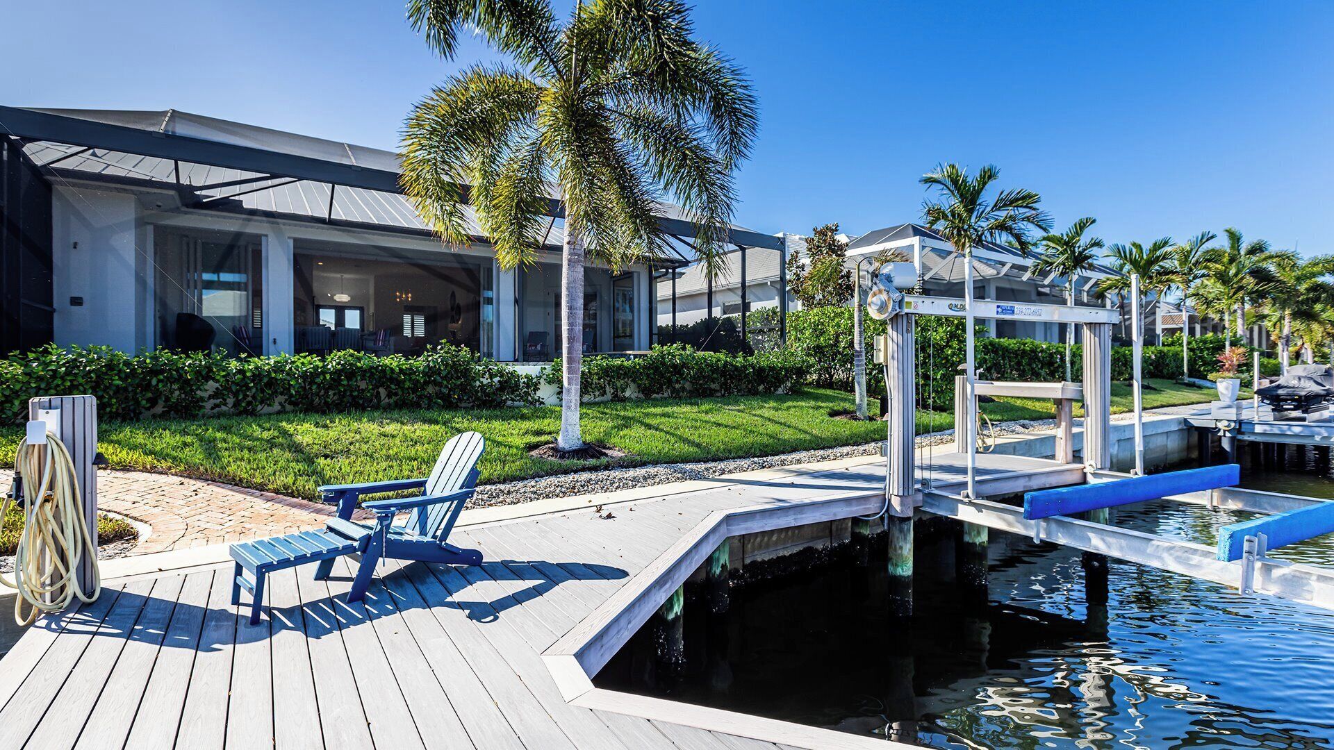 A modern hotel with a pool area, including a deck with a chair and a small water feature.