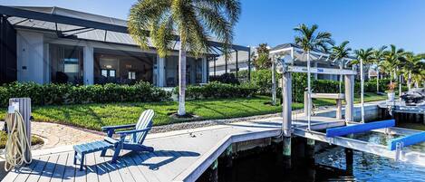 A modern hotel with a pool area, including a deck with a chair and a small water feature.