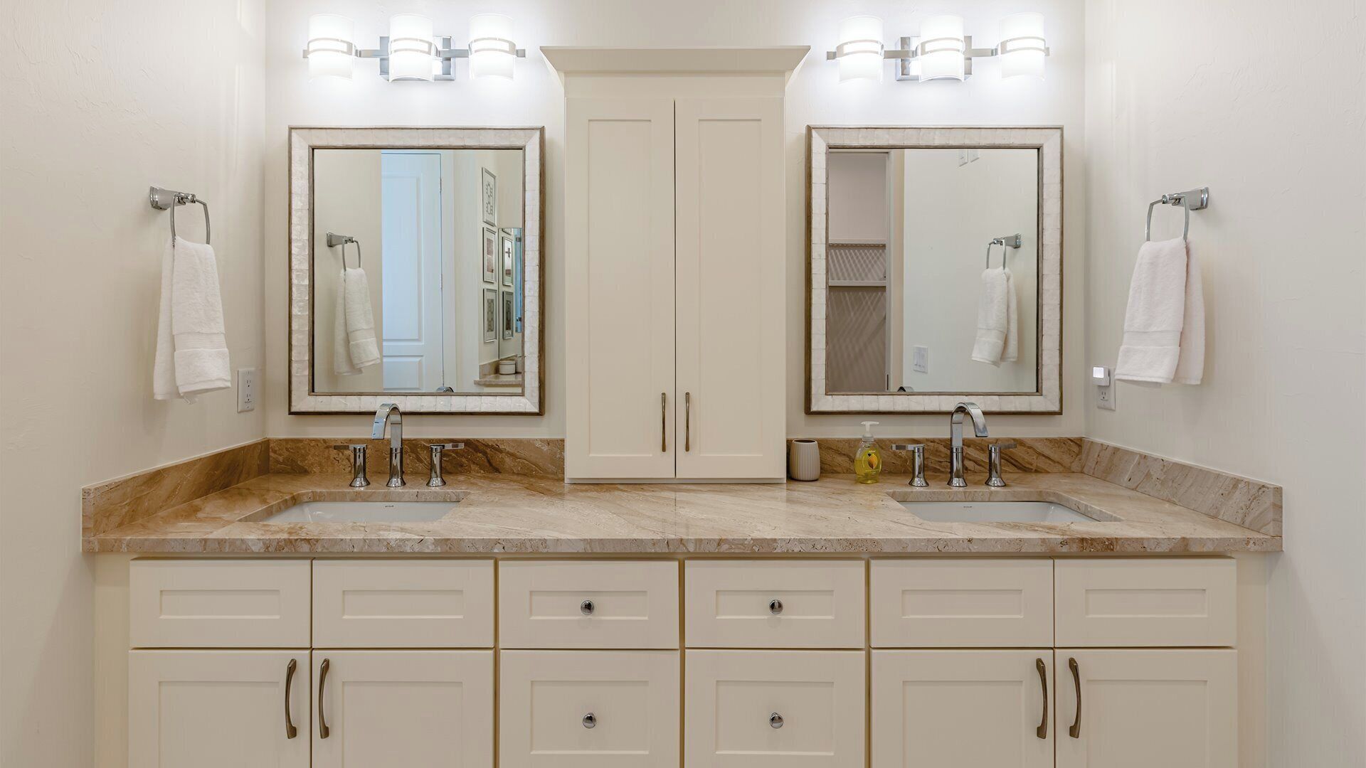 A bathroom with two sinks, a double vanity, and a large mirror.