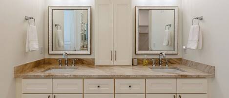 A bathroom with two sinks, a double vanity, and a large mirror.