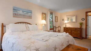 A bedroom with a bed, a dresser, a mirror, and a window with curtains. - Woods Edge: Walk to Red River Beach, Pet Friendly (Harwich Port)