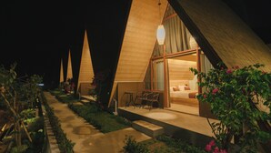 A row of triangular-roofed cabins with a garden path leading to the entrance. - Maya Ocean Resort (Kuta)