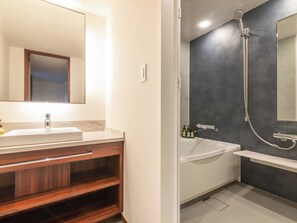 A modern bathroom with a wooden vanity, a large mirror, a sink, and a shower area. - ART HOTEL Kashima Central (Kamisu)
