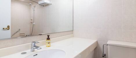 Un baño moderno con un lavabo grande, un espejo, una ducha y un inodoro.