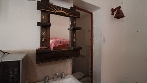Een badkamer met een houten wastafelmeubel, een wastafel en een spiegel.