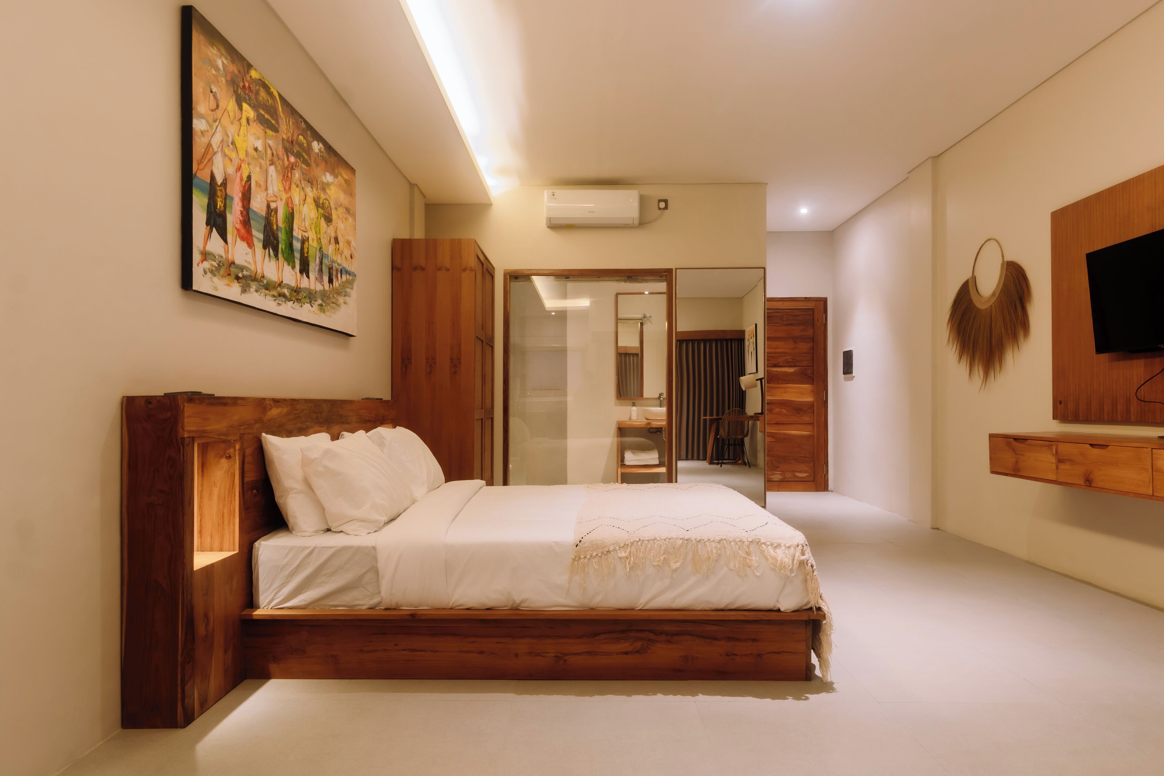 Une chambre à coucher avec un lit en bois, un tableau accroché au mur et un téléviseur fixé au mur.