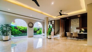 A spacious lobby with a marble floor, a reception desk, and a staircase leading to upper floors. - Campbar 4 (Munggu)