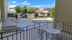 A terrace with a pool, white outdoor furniture, and a view of surrounding buildings. - 2 bed apartment for up to 6 people in awesome beachside Hampton (Hampton)