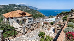 A villa with a tiled roof, a pool, and a view of the sea. - Villa Marcella with private pool and sea views (Massa Lubrense)