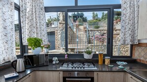 A kitchen with a view of a stone staircase and garden. - Villa Marcella with private pool and sea views (Massa Lubrense)
