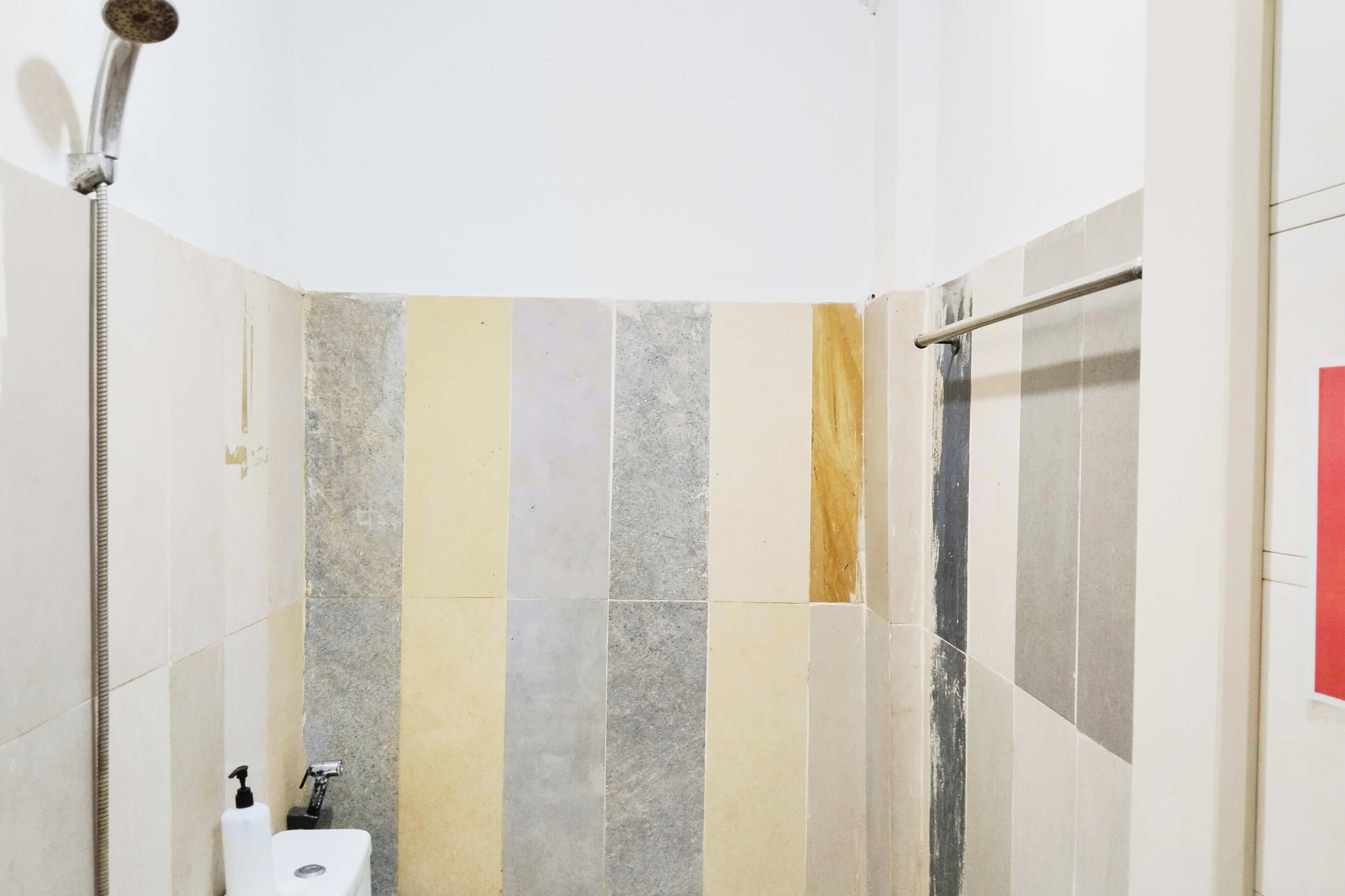 A bathroom with a shower, a toilet, and a hand dryer.