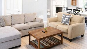 A living room with a ceiling fan, two sofas, a coffee table, and a fireplace.