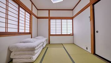 Una habitació japonesa tradicional amb tatami, un llit futón, portes corredisses i panells shoji.
