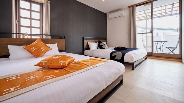 A hotel room with two beds, a large window, and a balcony. - Fuji Holiday (Fujiyoshida)