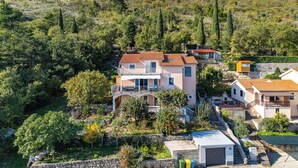 Zona residencial a la vora d'una collada, amb cases de parets de pedra i teulades vermelles.