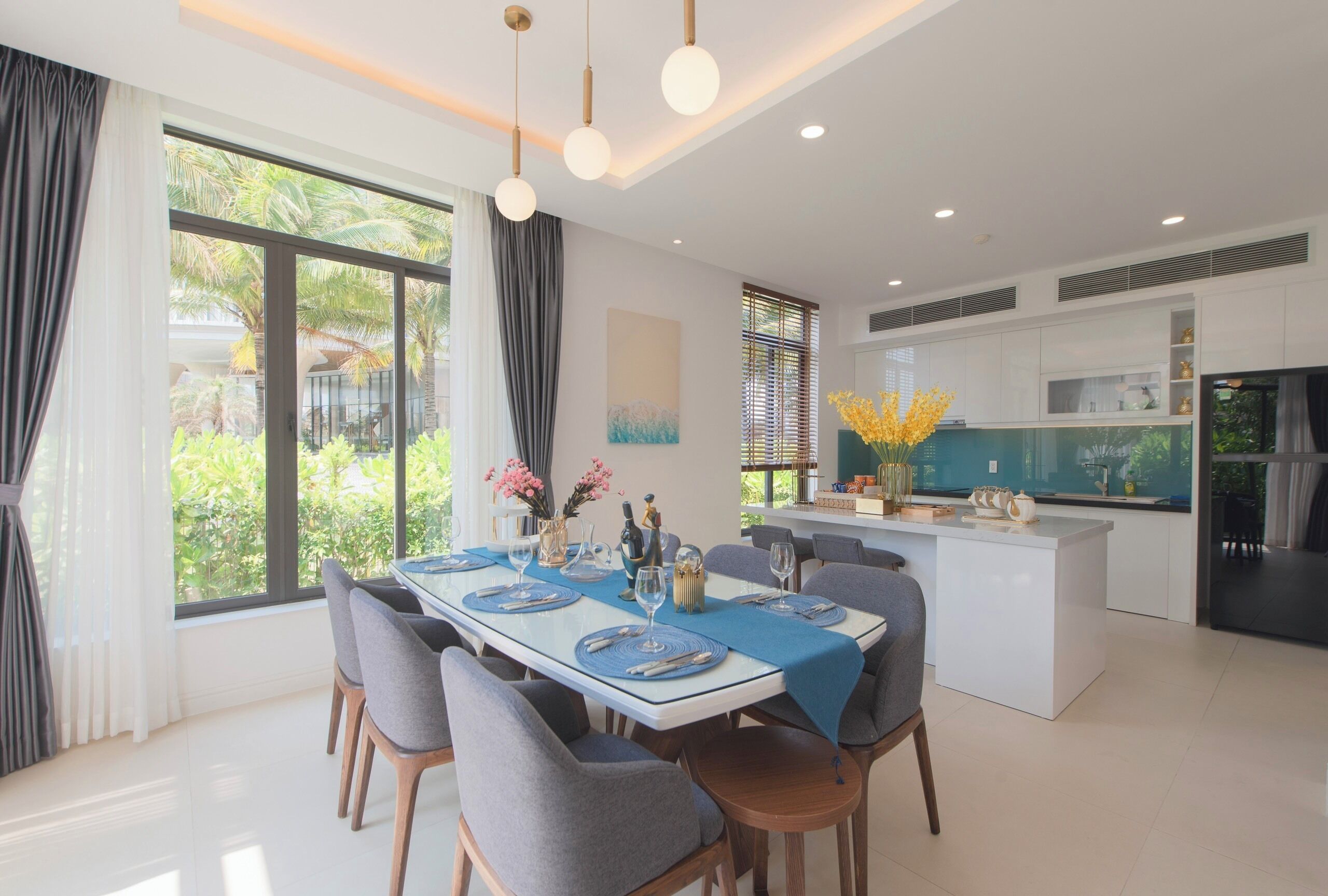 A modern dining area with a large table, chairs, and a kitchen island.