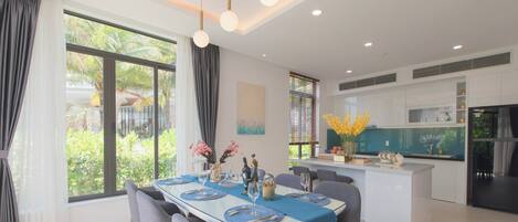 A modern dining area with a large table, chairs, and a kitchen island.