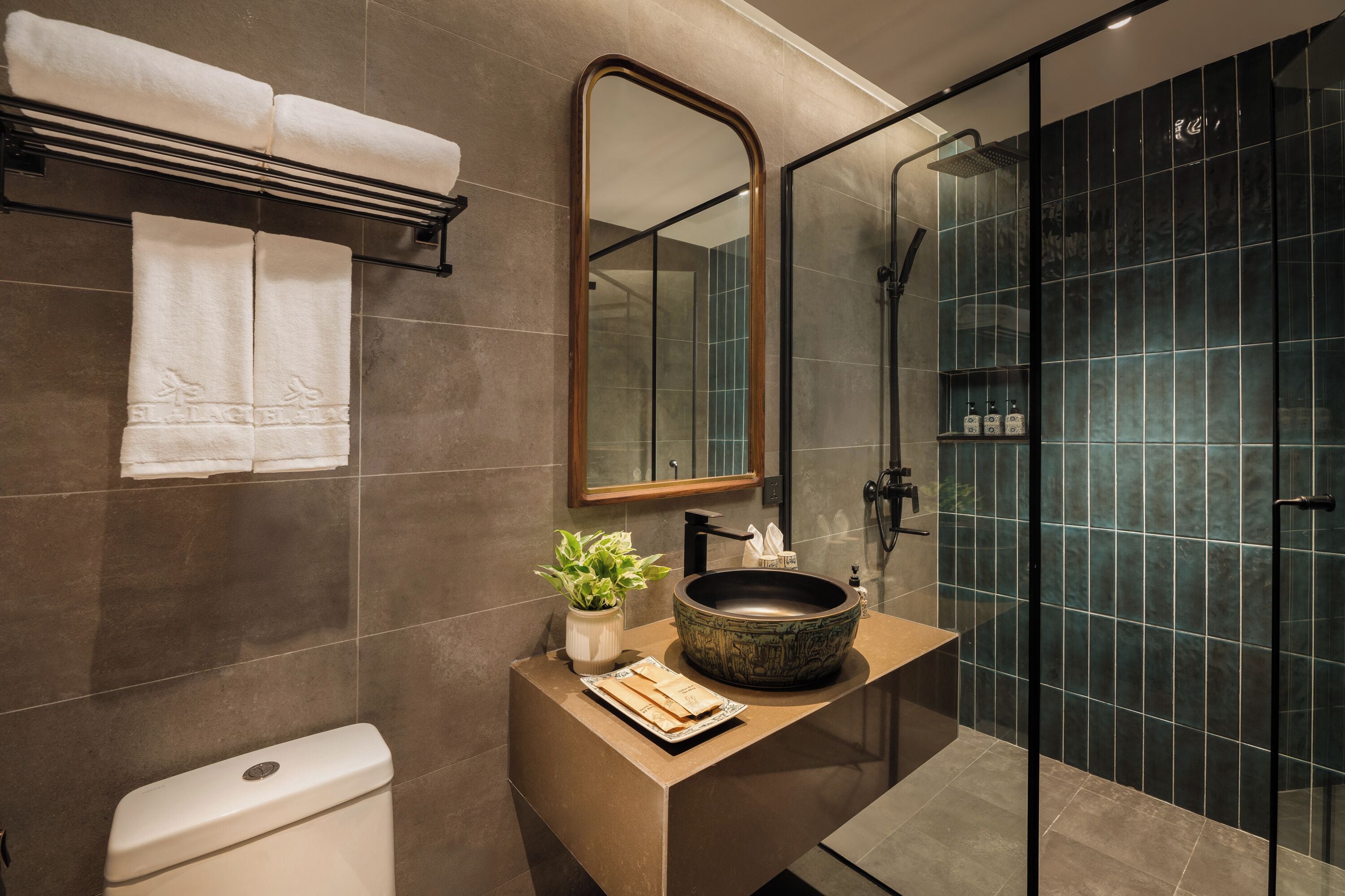 A modern bathroom with a large mirror, a vessel sink, and a glass-enclosed shower.