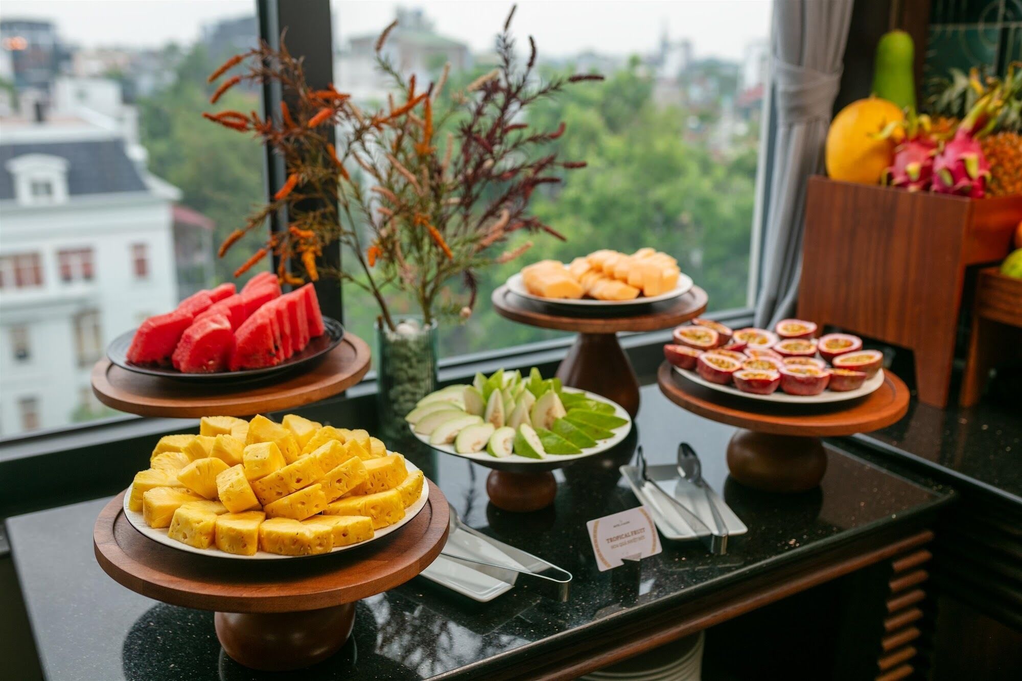 A buffet table with various fruits and desserts.