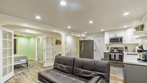 A compact living space with a kitchenette, a sofa, and a dining area.