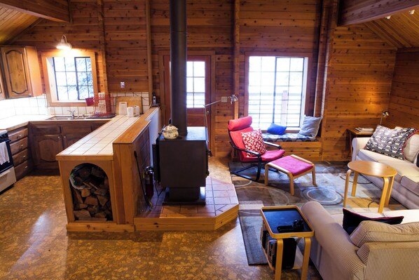 Un intérieur de chalet chaleureux comprenant une cuisine, un coin repas et un espace salon.