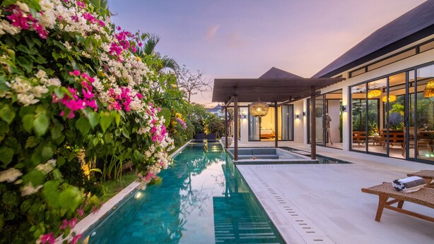 A poolside area with a clear view of the pool, a covered seating area, and a lush flower wall. - Private Pool • Outdoor Showers • Near Beaches (Uluwatu)