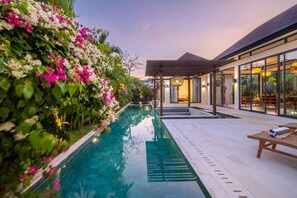 A poolside area with a clear view of the pool, a covered seating area, and a lush flower wall. - Tropical Pool Villa • King Bedrooms • Uluwatu (Uluwatu)