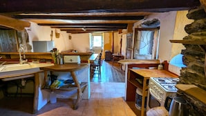 Eine rustikale Küche mit Holztisch, Spüle, Herd und einem Fenster mit Blick.