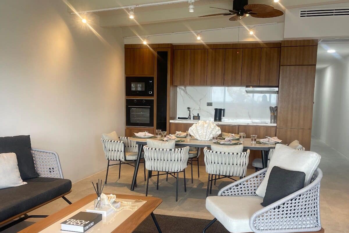 Una sala de estar moderna con un sofá, sillas, una mesita de centro y un comedor con mesa y sillas.