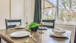 A dining table set with plates, cutlery, candles, and a potted plant. - 3 bedroom 2 bath Magical home (El Paso)