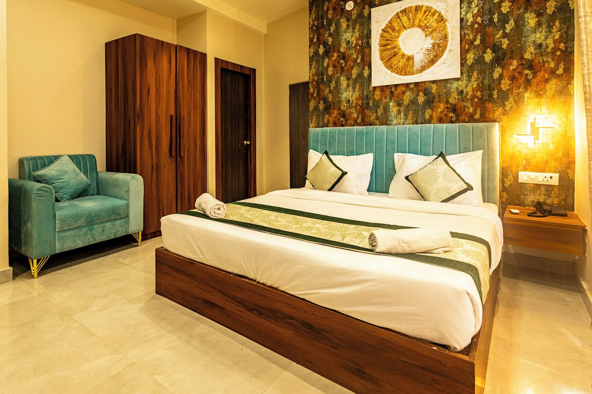 Un dormitorio con una cama, un sofá, un armario y una pared decorada.
