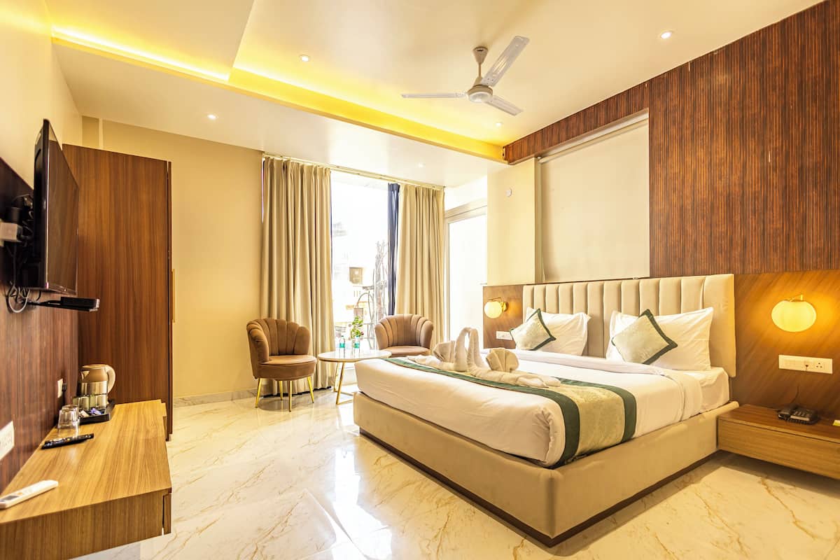 Habitación de hotel moderna con una cama grande, un escritorio, una silla y un televisor.