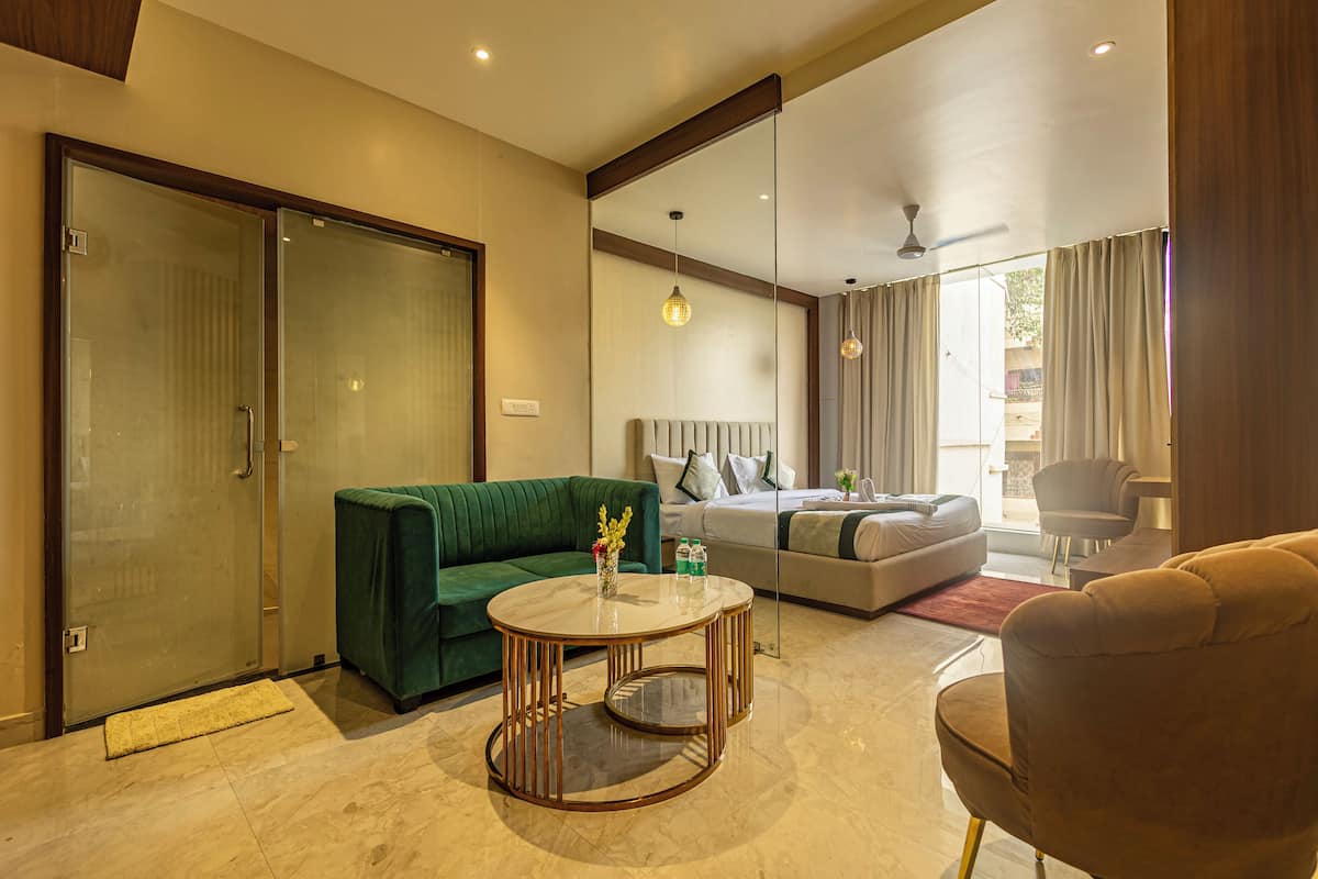Una sala de estar moderna con un sofá verde, una mesa de centro redonda y un sofá beige.